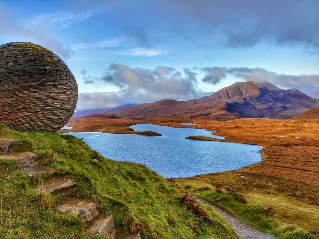 Ullapool pe malul mării și peisaj montan din Highlands scoțiani